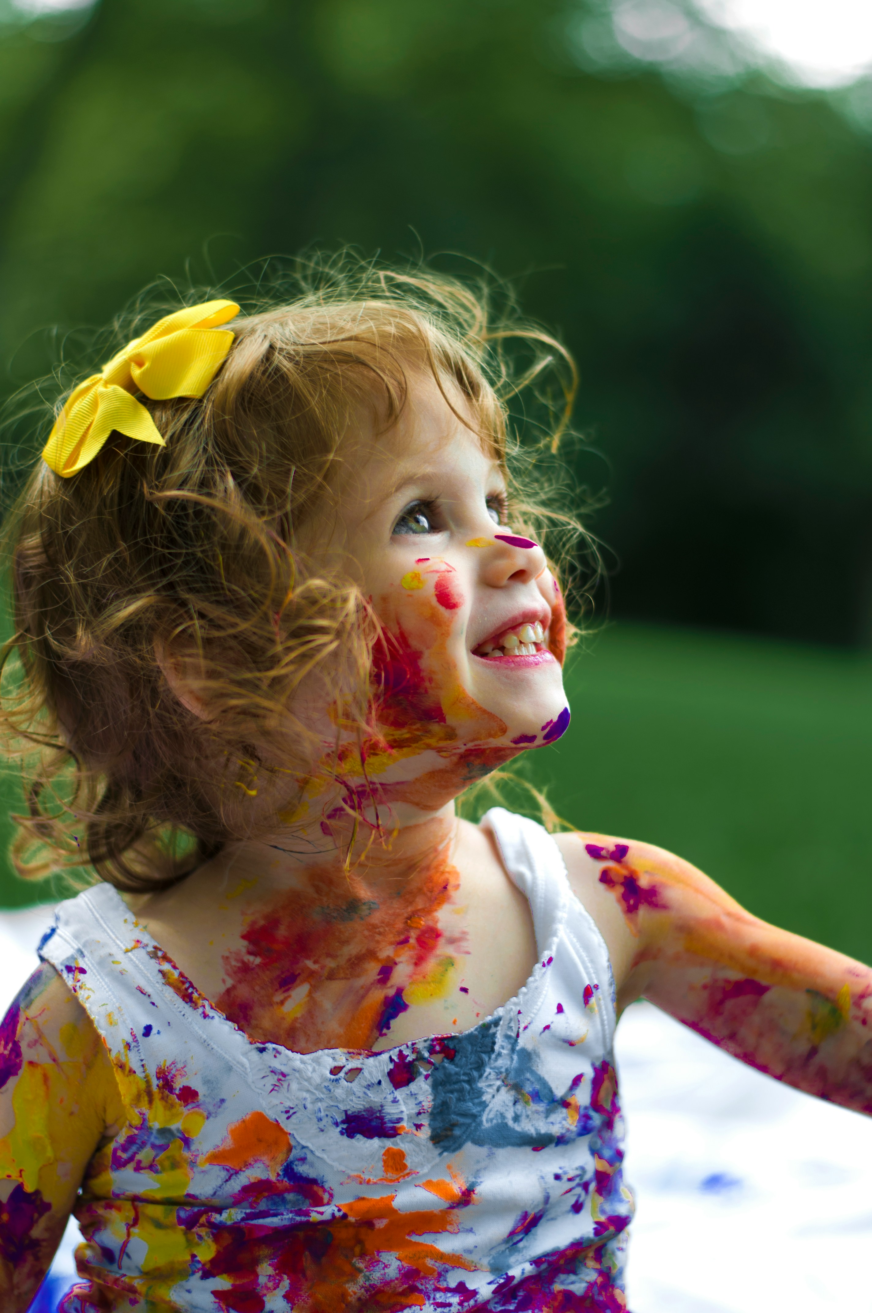 Child joyfully covered in paint — creativity at Bloom